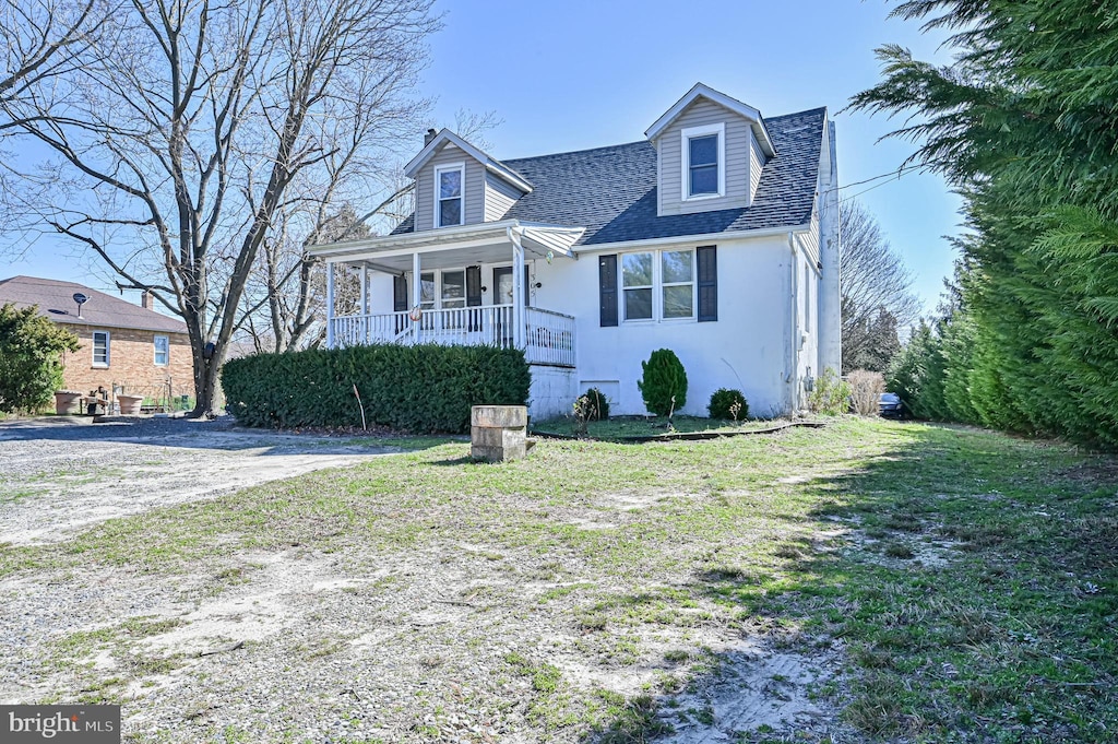 cape cod-style house with covered porch and a front lawn