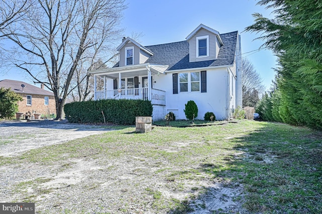 cape cod-style house with covered porch and a front lawn