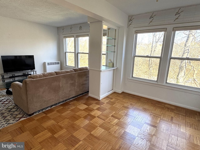 living room featuring a textured ceiling and baseboards