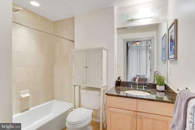 full bathroom featuring toilet, tiled shower / bath, and vanity