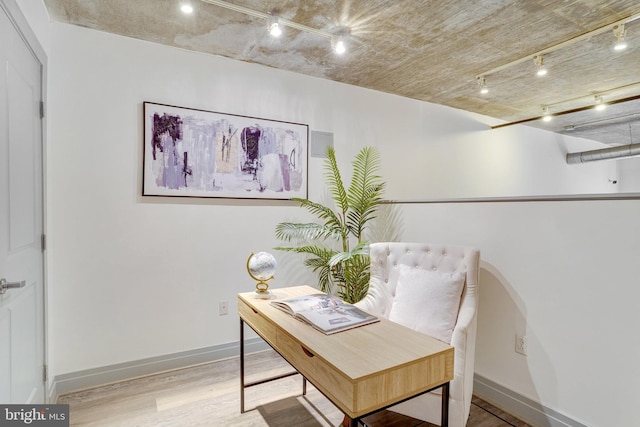 office area with track lighting and light wood-type flooring