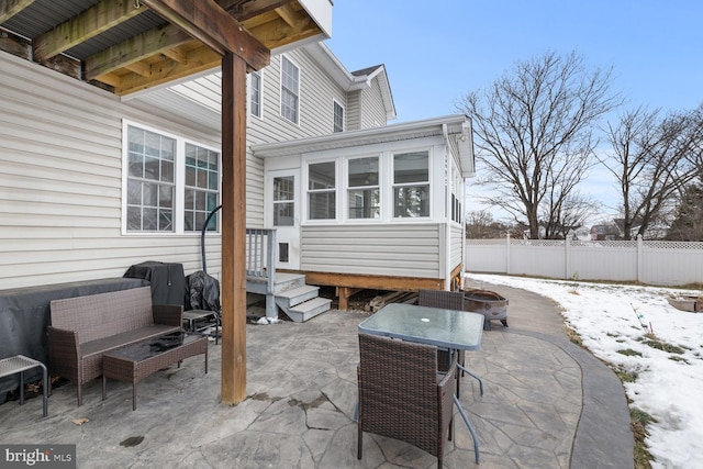 snow covered patio with an outdoor living space with a fire pit