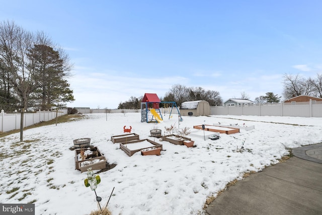 snowy yard featuring a playground