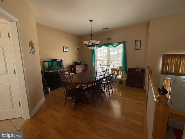 dining room with hardwood / wood-style floors and a chandelier