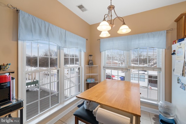 dining space featuring light tile patterned flooring and an inviting chandelier