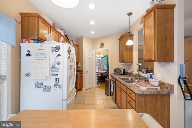 kitchen featuring pendant lighting, sink, white fridge with ice dispenser, stainless steel dishwasher, and light tile patterned floors