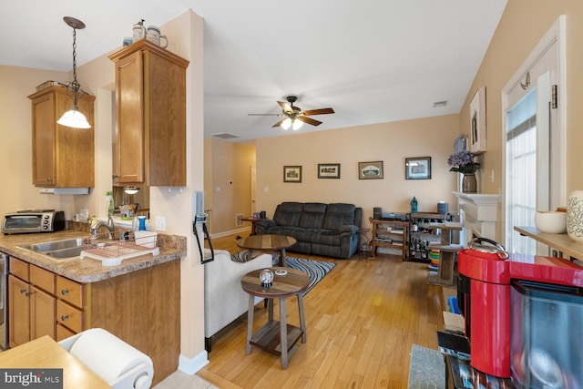 living room featuring sink, ceiling fan, and light wood-type flooring