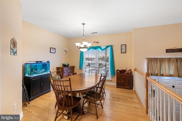 dining space with a chandelier and light hardwood / wood-style floors