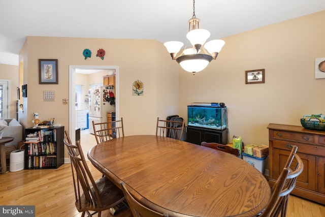 dining space with a notable chandelier and light hardwood / wood-style floors