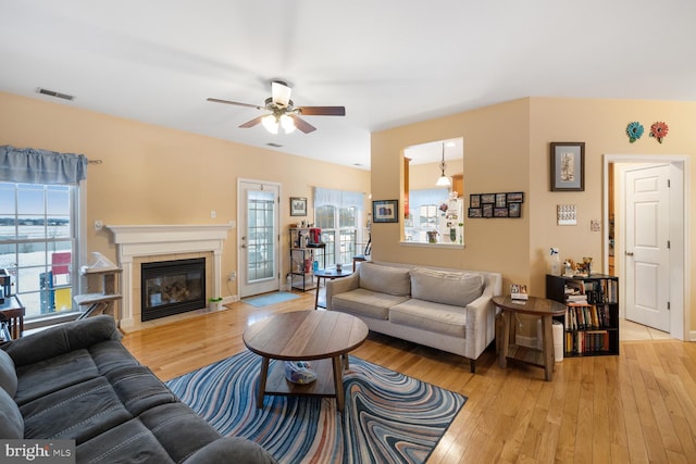 living room featuring light hardwood / wood-style flooring and ceiling fan