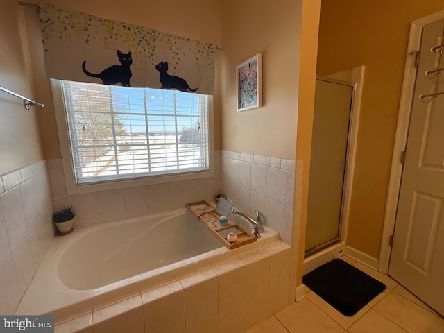 bathroom with tile patterned floors and shower with separate bathtub