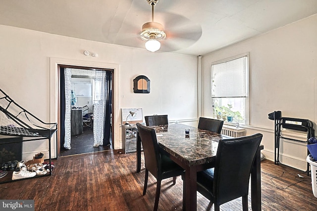 dining area with a ceiling fan and dark wood-style flooring
