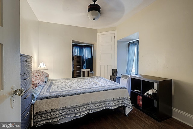 bedroom featuring baseboards, wood finished floors, and ceiling fan