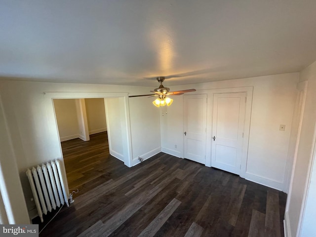unfurnished bedroom featuring baseboards, radiator heating unit, and dark wood-style floors