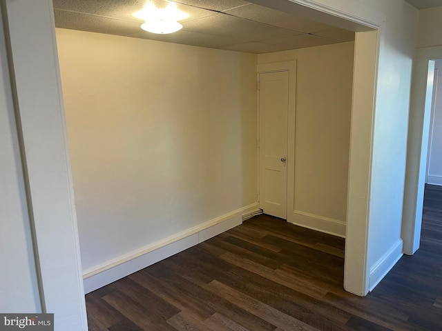 spare room featuring baseboards and dark wood finished floors