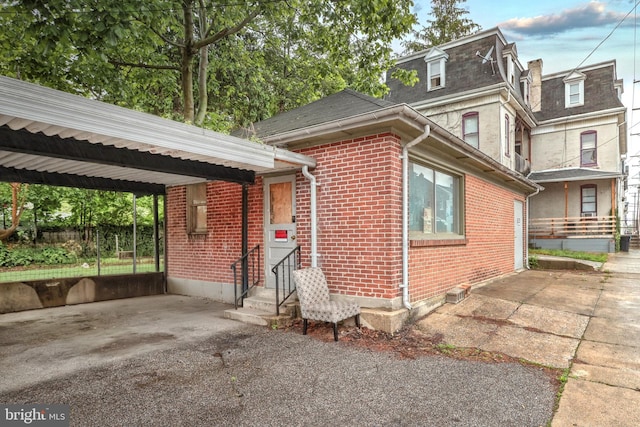 view of side of home featuring fence, entry steps, and brick siding