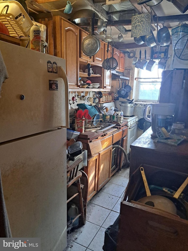 kitchen with white fridge and light tile patterned flooring