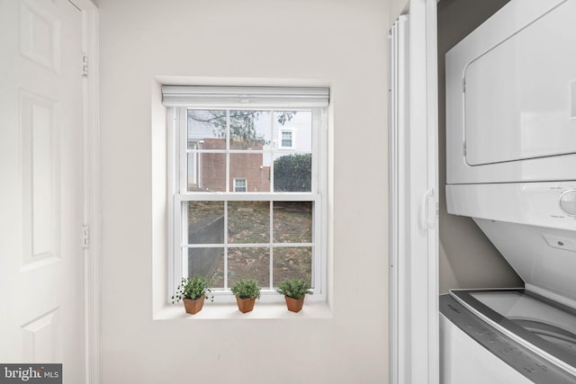 laundry area featuring plenty of natural light and stacked washer and clothes dryer