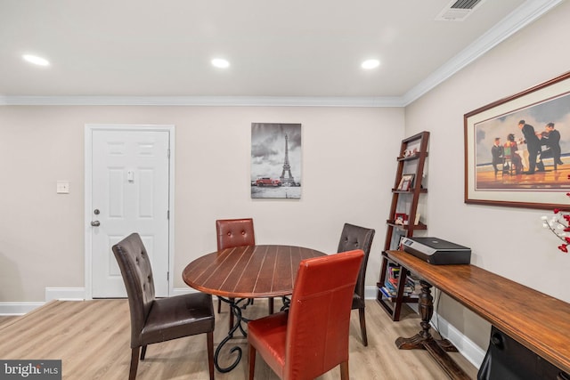 dining space featuring crown molding and light hardwood / wood-style floors