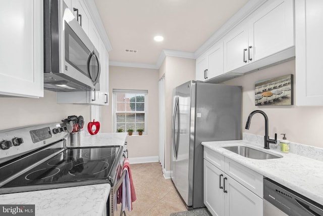 kitchen featuring sink, light stone counters, white cabinetry, and appliances with stainless steel finishes