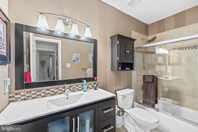 full bathroom with backsplash, bath / shower combo with glass door, toilet, and vanity