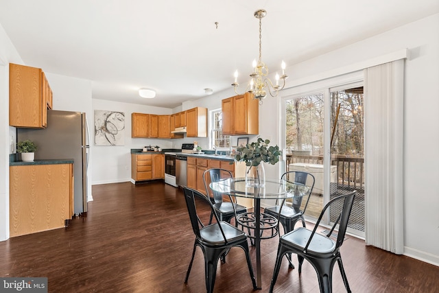 dining area featuring dark hardwood / wood-style floors, sink, and an inviting chandelier