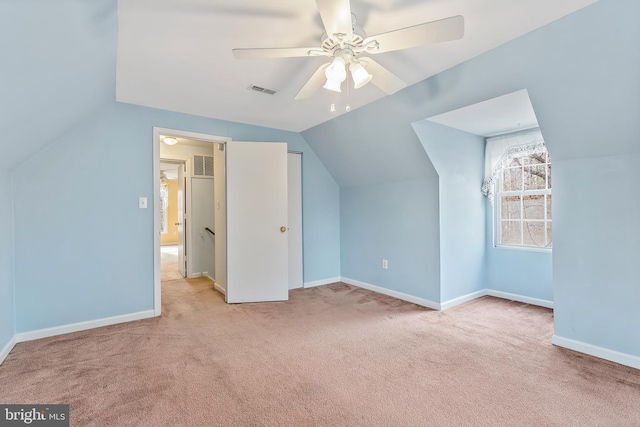 additional living space with vaulted ceiling, light carpet, and ceiling fan