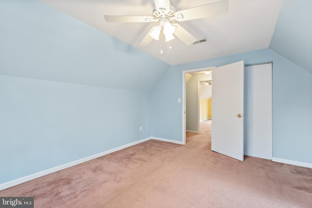 additional living space featuring vaulted ceiling, light colored carpet, and ceiling fan