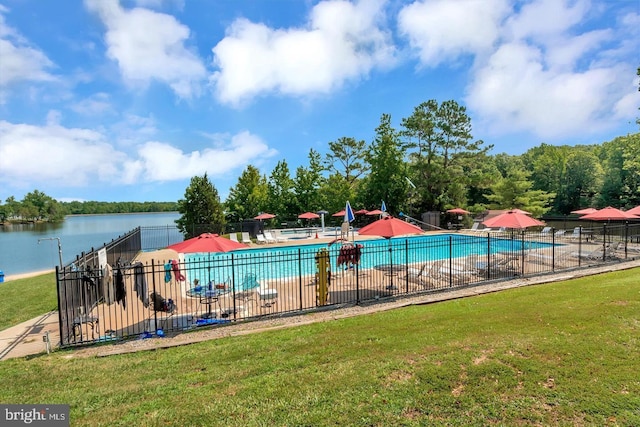 view of swimming pool featuring a water view and a yard