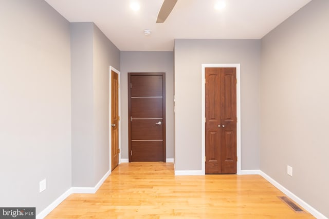 unfurnished bedroom featuring ceiling fan, a closet, and light hardwood / wood-style flooring