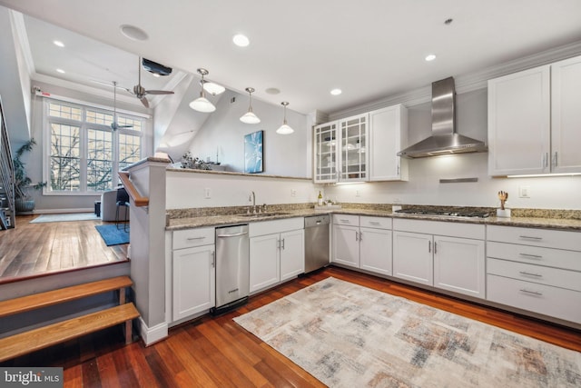 kitchen featuring wall chimney range hood, white cabinetry, and pendant lighting