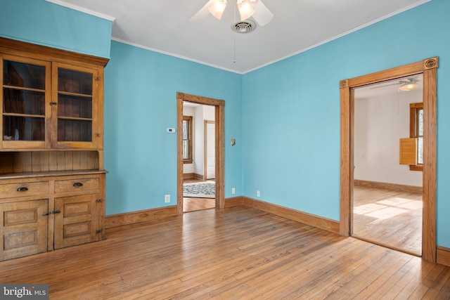 empty room with ceiling fan, light hardwood / wood-style flooring, and crown molding