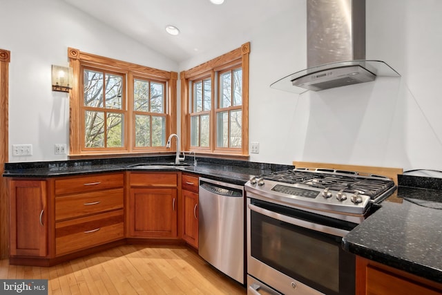 kitchen featuring dark stone countertops, appliances with stainless steel finishes, sink, lofted ceiling, and ventilation hood