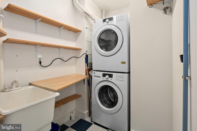 clothes washing area featuring stacked washer and dryer