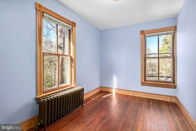 unfurnished room featuring dark wood-type flooring and radiator