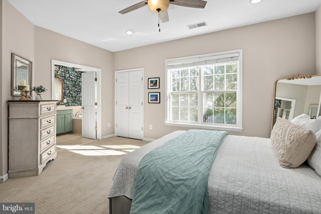 carpeted bedroom featuring connected bathroom and ceiling fan