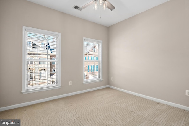 carpeted empty room with ceiling fan and a healthy amount of sunlight