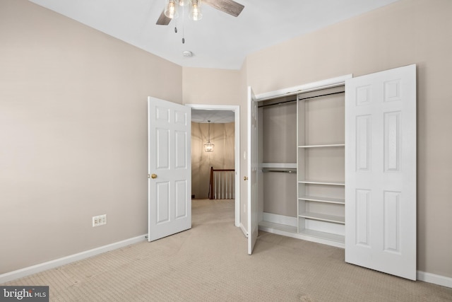 unfurnished bedroom with ceiling fan, a closet, and light carpet