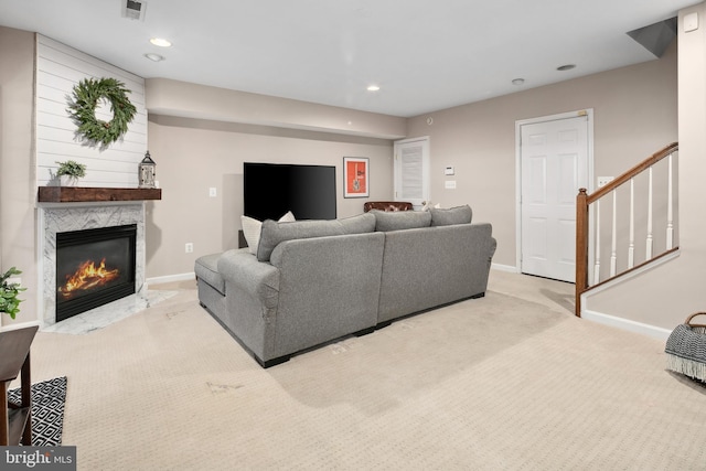 living room with light carpet and a high end fireplace