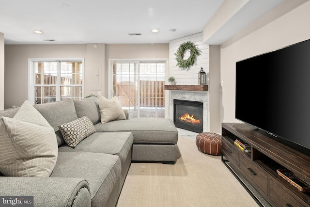 living room featuring a healthy amount of sunlight and a high end fireplace