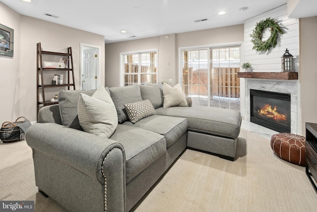 living room featuring light carpet and a premium fireplace