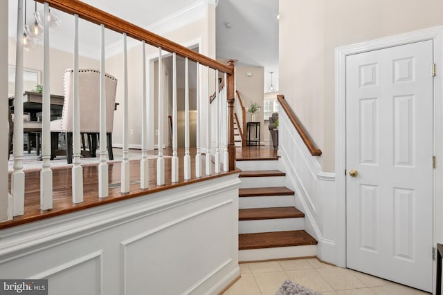 staircase featuring tile patterned flooring and ornamental molding