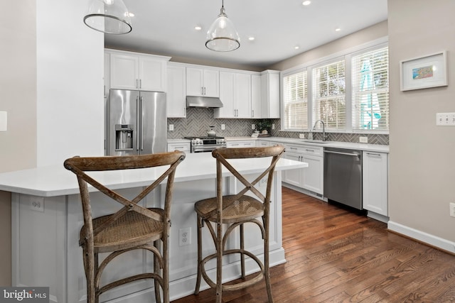 kitchen featuring pendant lighting, sink, white cabinets, and appliances with stainless steel finishes