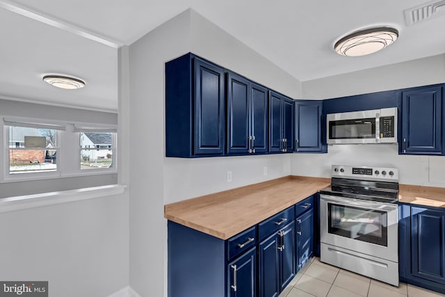 kitchen with light tile patterned floors, appliances with stainless steel finishes, wood counters, and blue cabinets