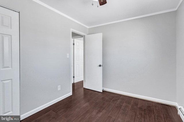 spare room featuring a baseboard heating unit, ceiling fan, crown molding, and dark hardwood / wood-style floors