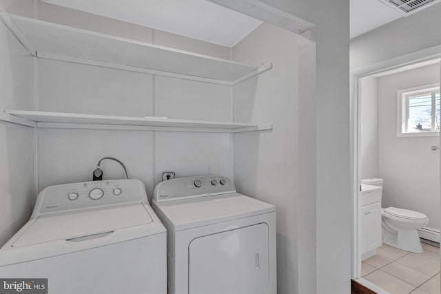 laundry room with light tile patterned floors, washer and clothes dryer, and a baseboard radiator