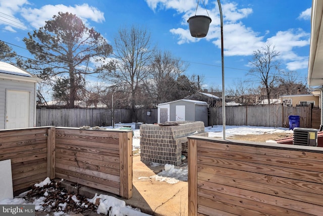 snow covered deck featuring a storage unit