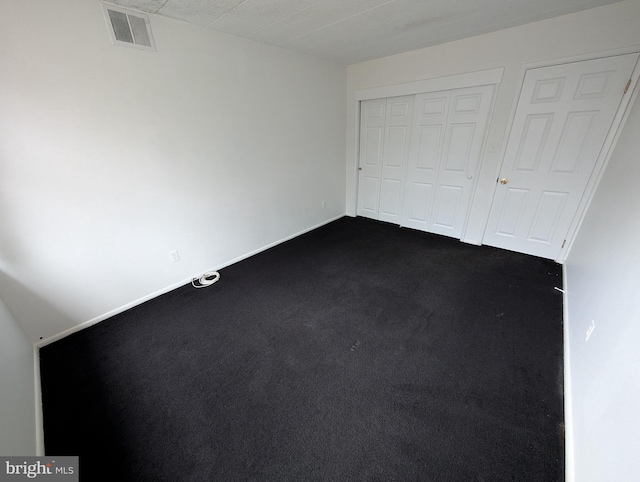 unfurnished bedroom featuring dark carpet