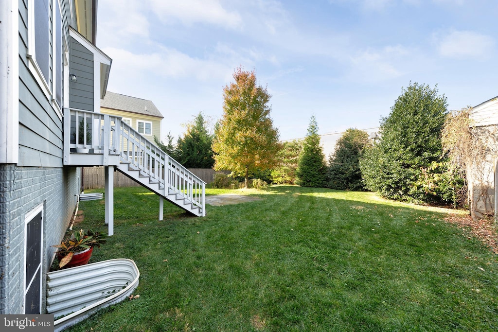 view of yard featuring fence and stairway