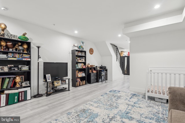 bedroom with a crib and hardwood / wood-style floors